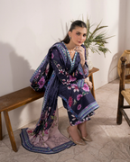 Woman in a floral kimono sitting on a wooden bench with a plant in the background.