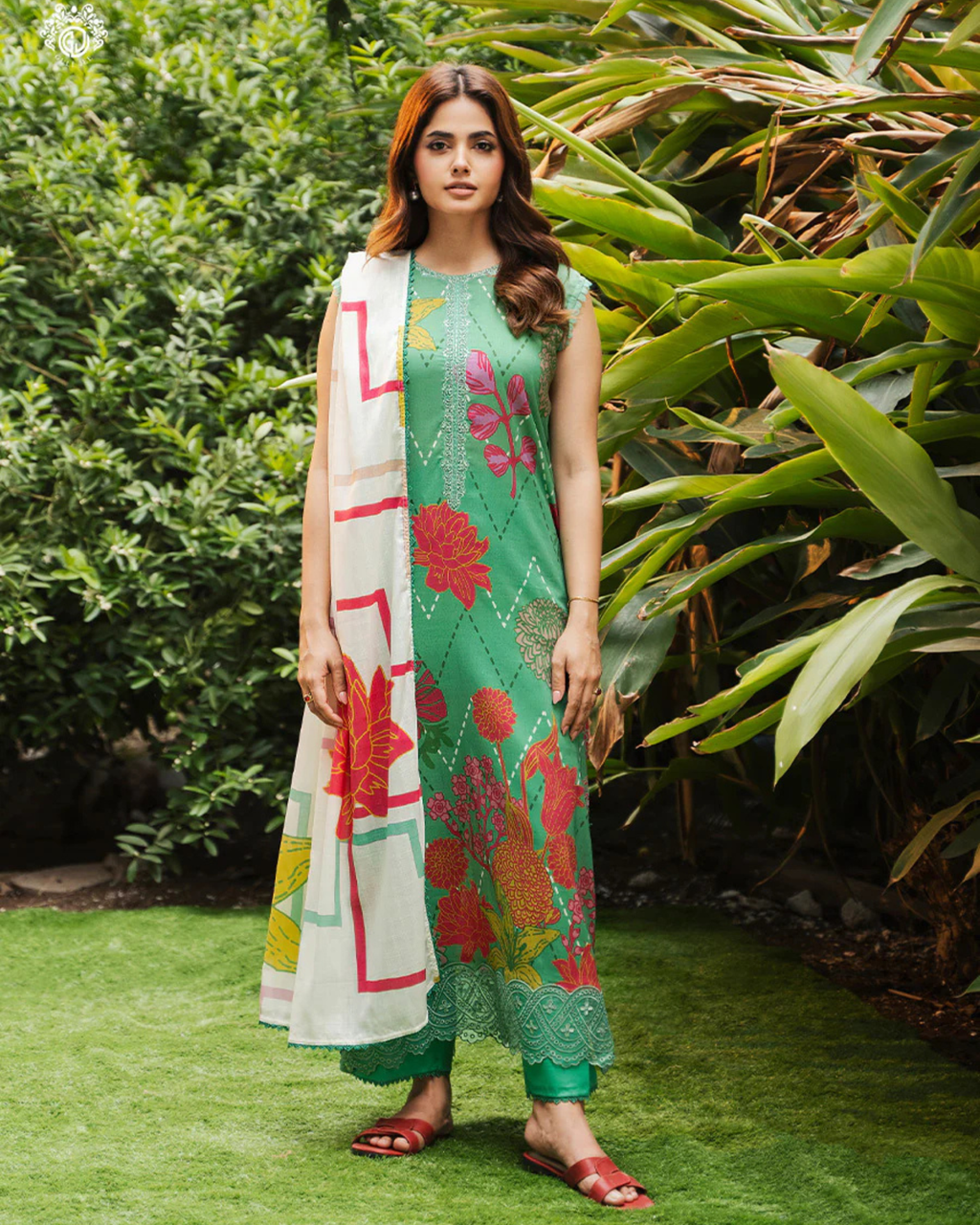 Woman in a green floral dress standing in a garden