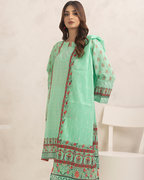 Woman wearing a light green traditional outfit with floral patterns on a neutral background