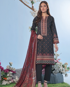 Woman wearing a black embroidered dress with a red dupatta in a garden setting