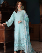 Woman wearing a light blue embroidered dress in an indoor setting
