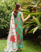 Woman in a green and white floral saree standing in a garden
