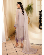 Woman in a light-colored traditional outfit with a matching dupatta in an elegant indoor setting.