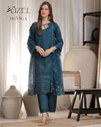 Woman wearing a teal embroidered outfit with a matching dupatta in a decorative room.