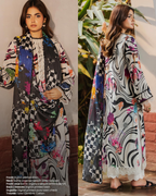 Woman wearing a colorful patterned outfit with a checkered shawl, standing indoors.