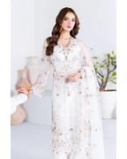 Woman wearing a white embroidered outfit with a neutral background