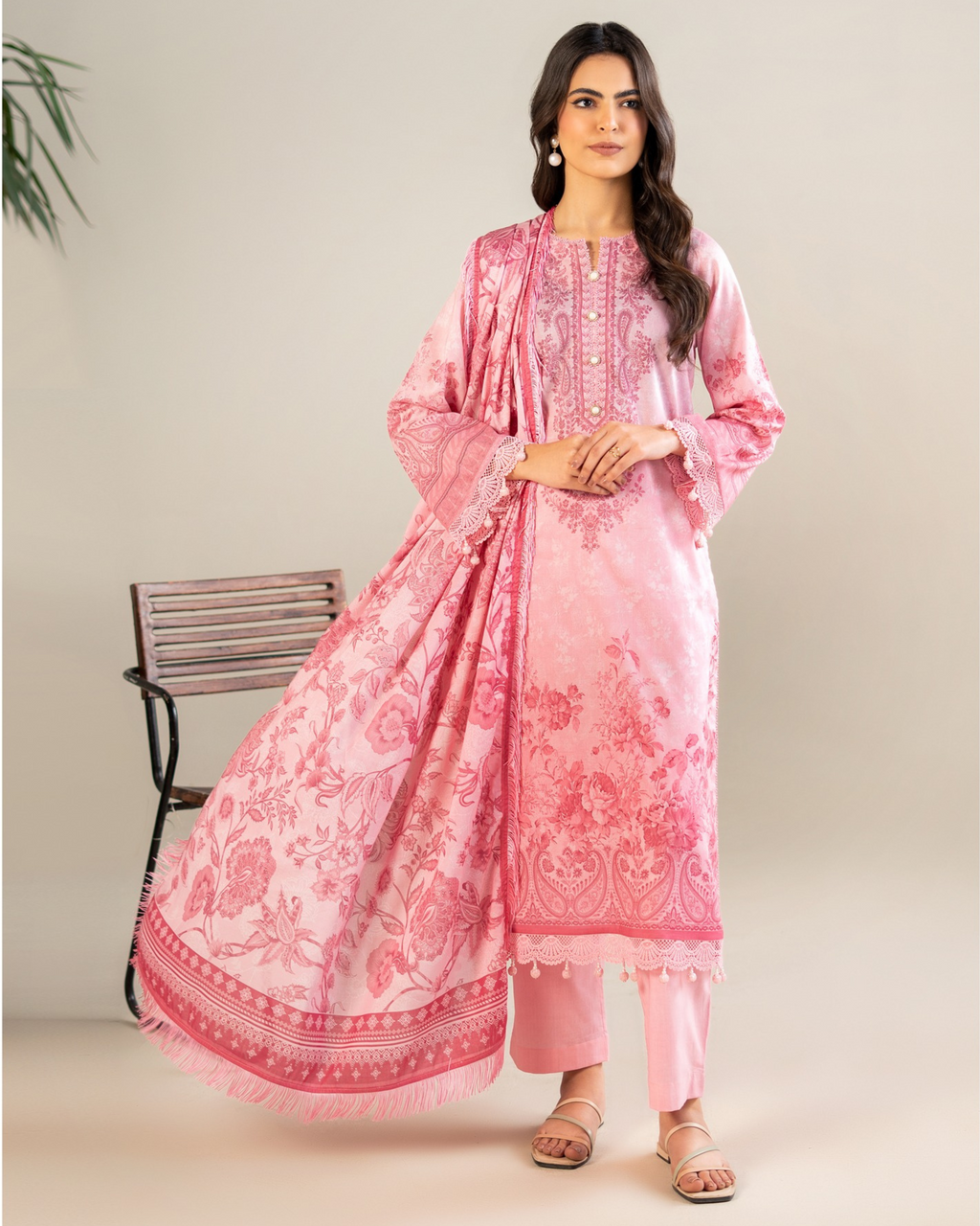 Woman wearing a pink traditional outfit with floral patterns on a beige background