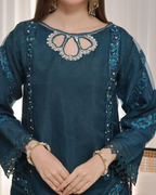 Teal embroidered blouse with intricate designs on a plain background