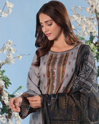 Woman wearing a patterned outfit with cherry blossom trees in the background
