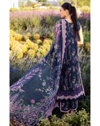 Woman in a dark blue floral dress standing in a field of flowers