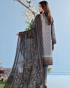 Woman holding a patterned dupatta against a blue sky background