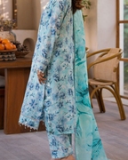 Person wearing a light blue floral outfit in an indoor setting