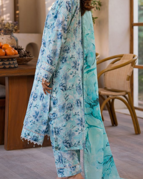 Person wearing a light blue floral outfit in an indoor setting