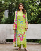 Woman wearing a bright green floral dress with a colorful dupatta against a natural background