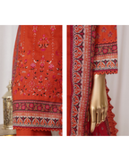 Red fabric with intricate patterns and a gold hand on a white background