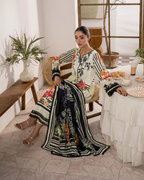Woman in a floral dress sitting at a table with a decorative setting.