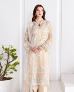 Woman wearing a beige embroidered outfit with a white background