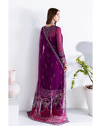 Woman wearing a purple saree with intricate designs on a white background