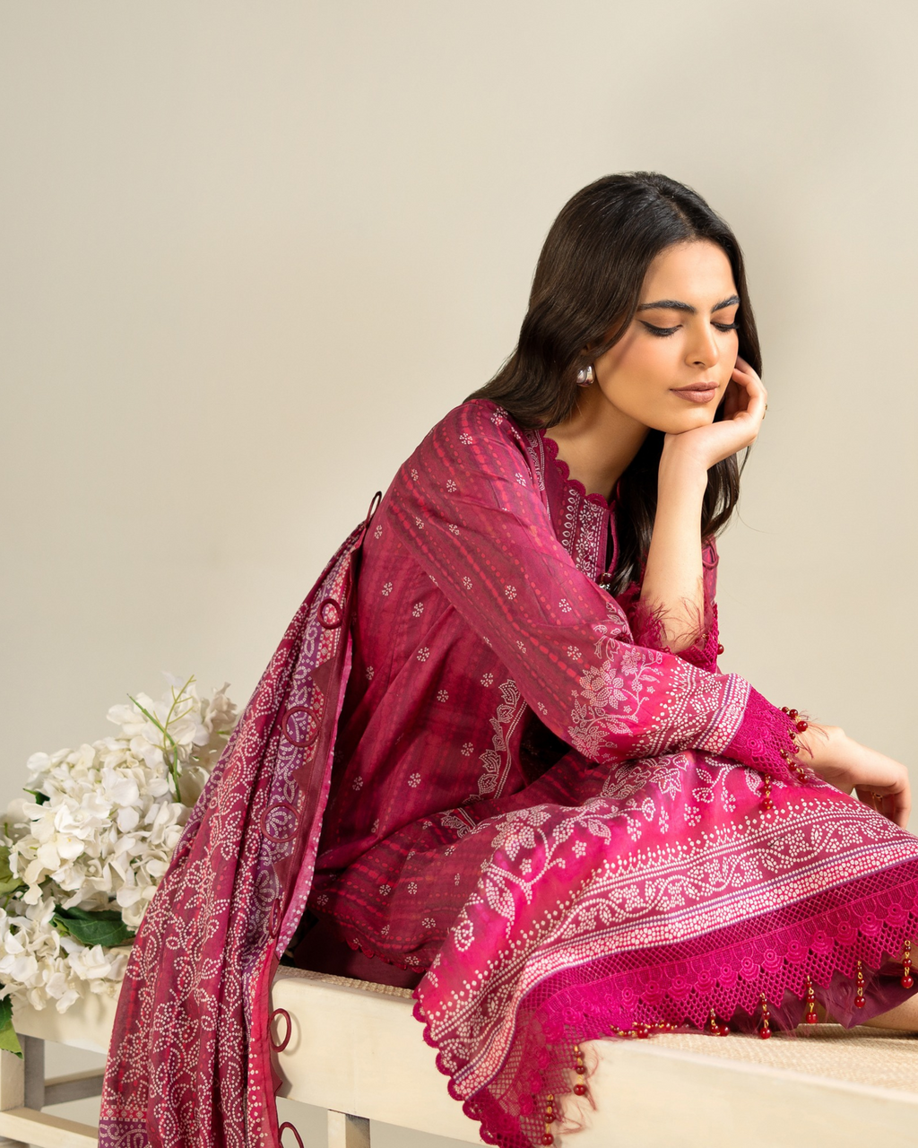 Woman in a pink traditional outfit with a floral background