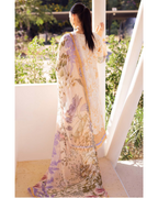 Woman wearing a floral dress standing on a balcony with greenery in the background