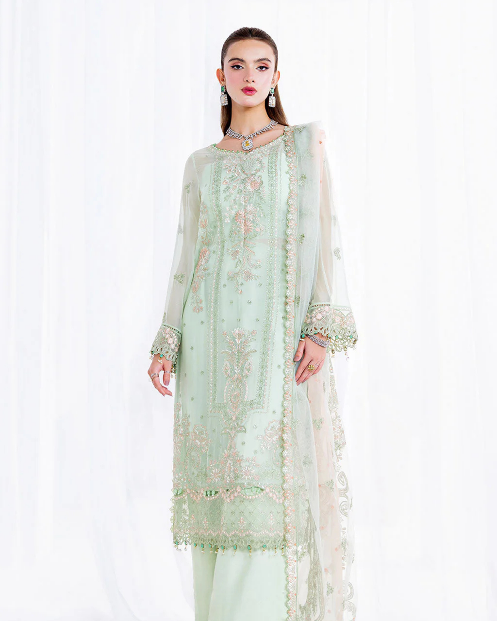 Light green embroidered traditional outfit on a white background