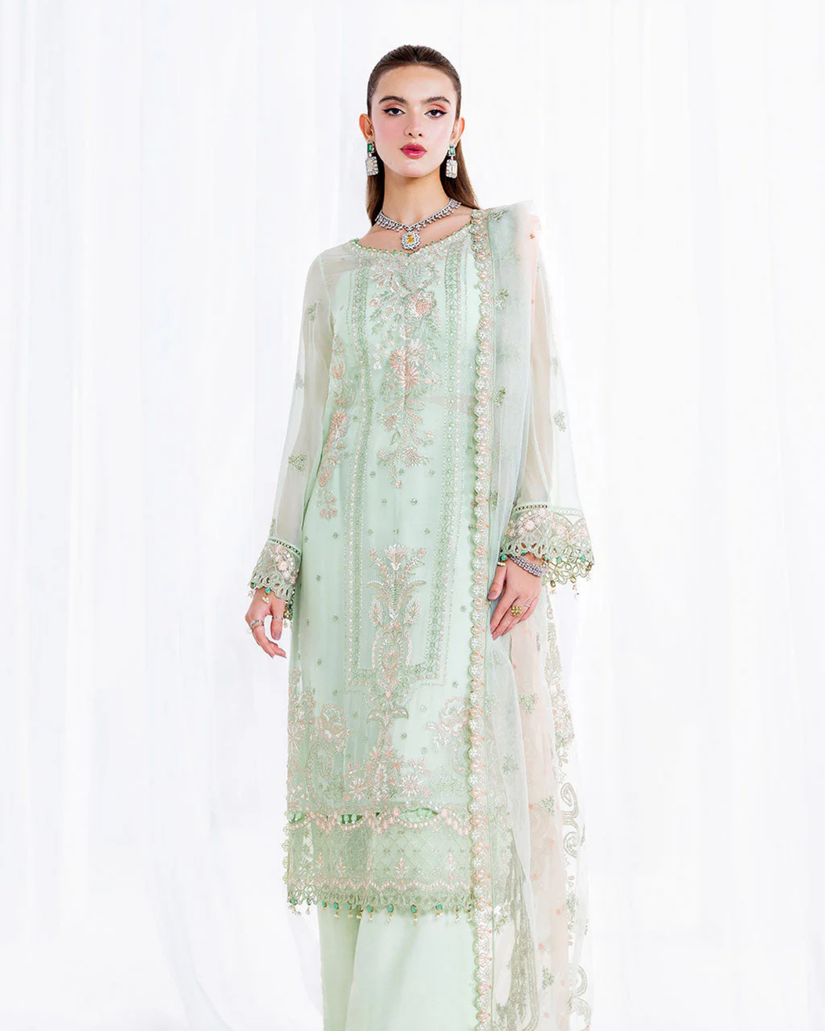 Light green embroidered traditional outfit on a white background
