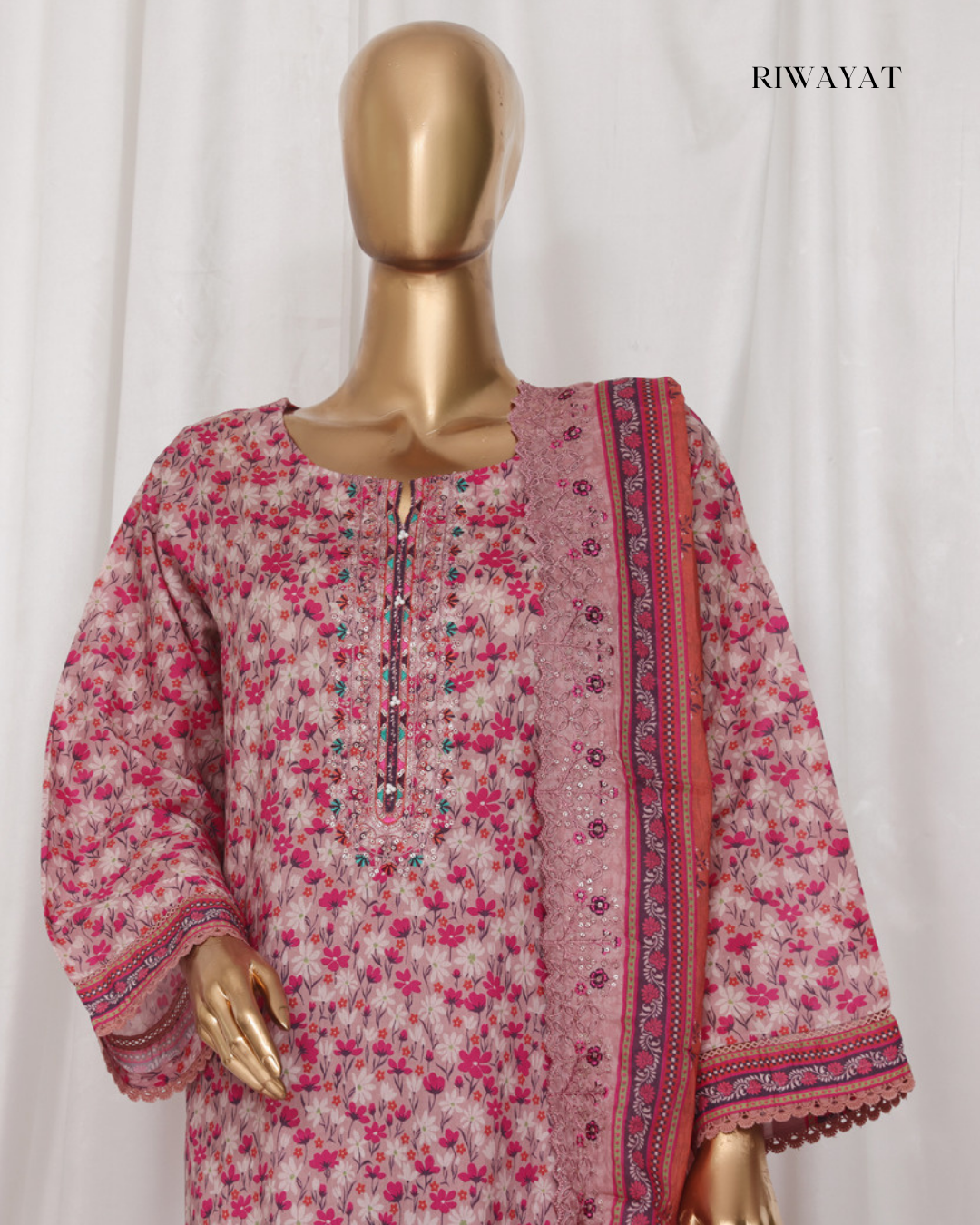 Mannequin wearing a pink floral dress with a matching dupatta on a white background, branded 'RIWAYAT'.