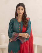 Woman wearing a teal and red traditional outfit with intricate patterns on a white background