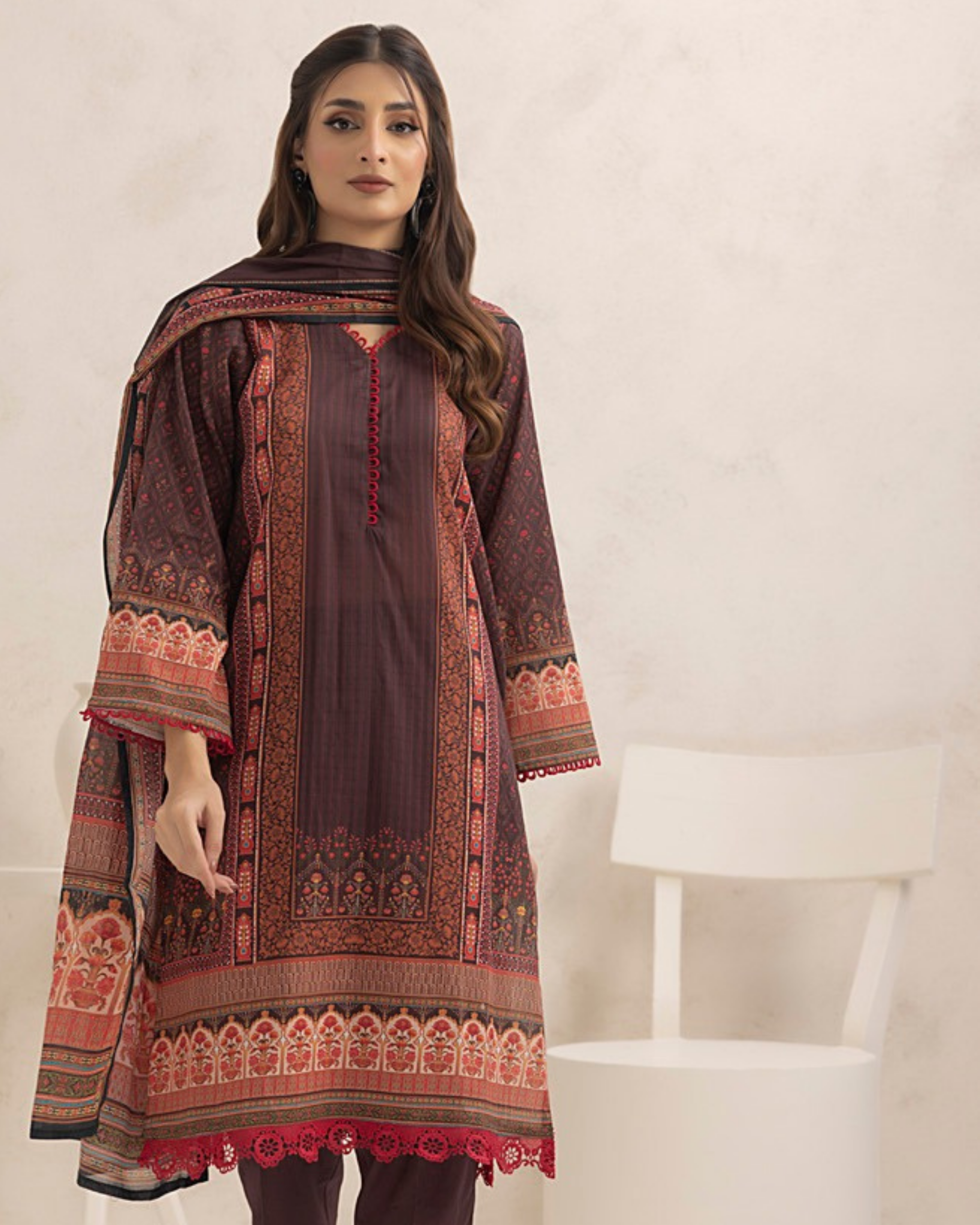 Woman wearing a traditional outfit with intricate patterns on a white background