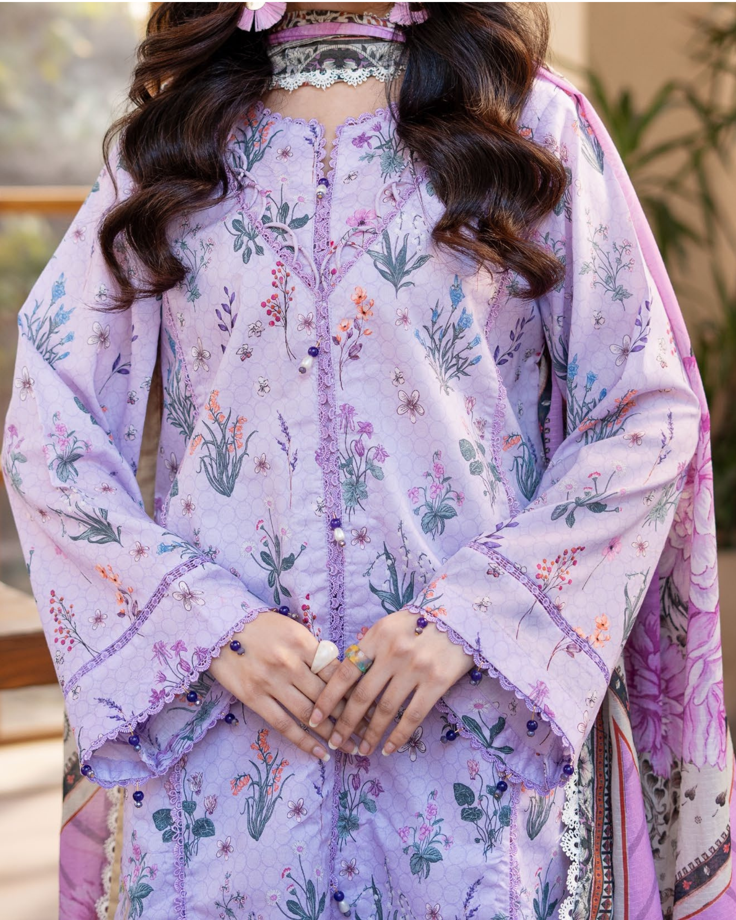 Person wearing a floral embroidered outfit with a blurred background