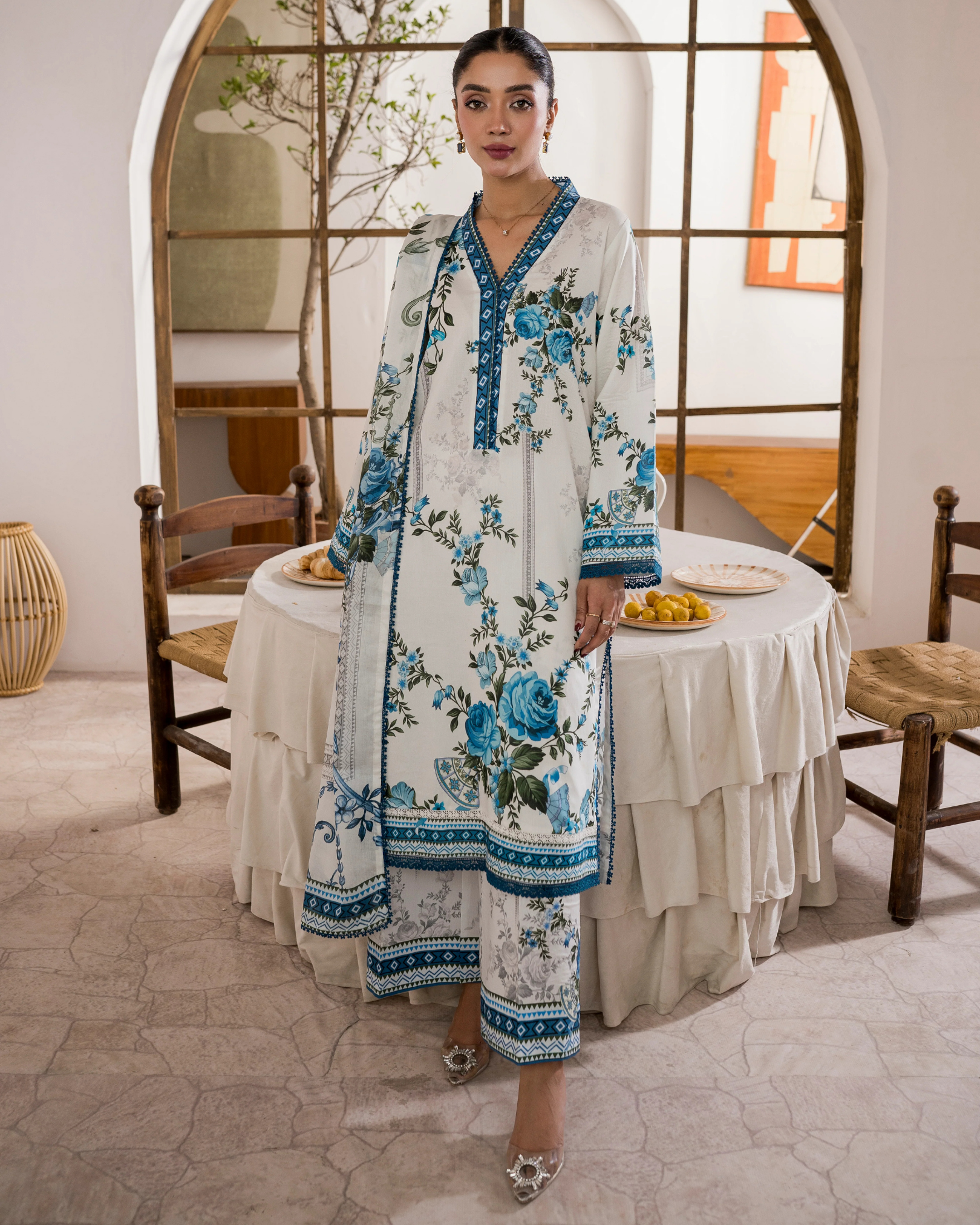 Woman in a floral dress standing in a dining room.