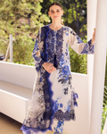 Woman wearing a blue and white floral dress standing outdoors.