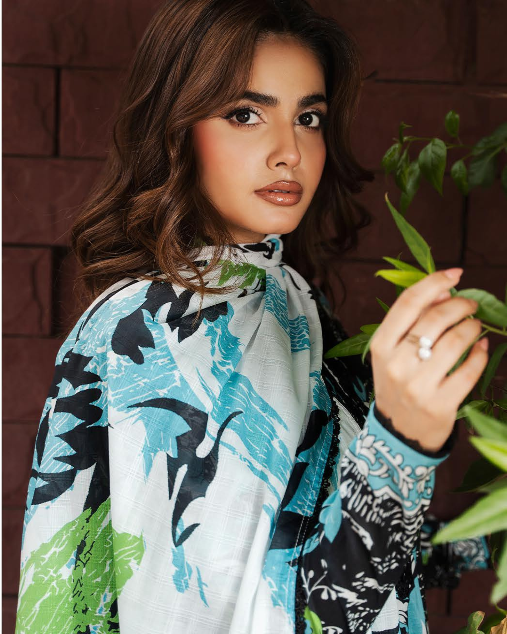 Woman wearing a colorful patterned scarf with a brown background