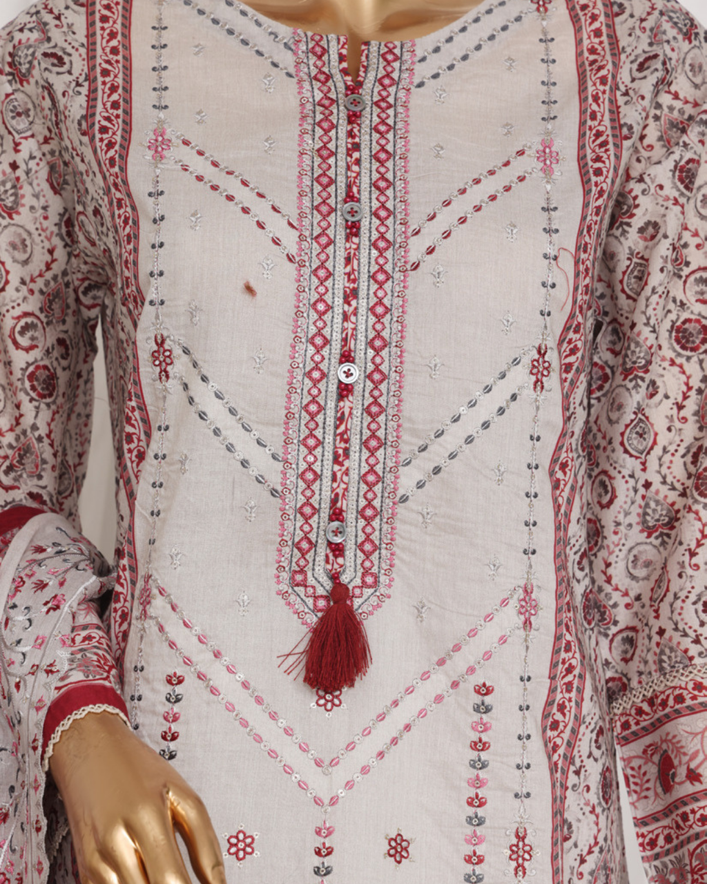 Embroidered traditional outfit with red and white patterns on a mannequin.