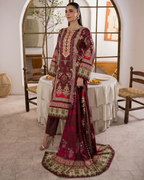 Woman in a traditional embroidered outfit standing in a room with a table and chairs.