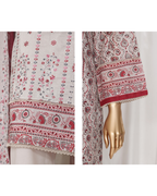 Embroidered fabric with red and white patterns on a mannequin arm.