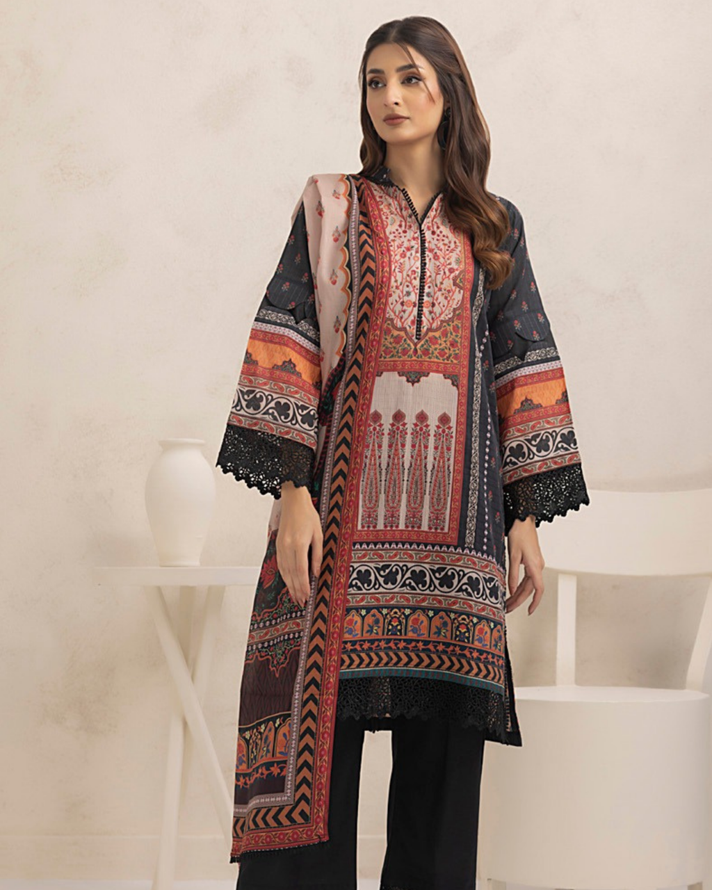 Woman wearing a patterned black and red kurta with a white background
