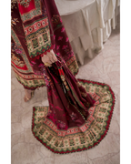 Traditional embroidered fabric with intricate patterns on a textured floor.