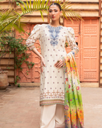 Woman in a traditional outfit with a colorful dupatta standing in front of a textured wall.