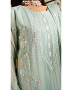 Light green embroidered garment with intricate patterns on a plain background