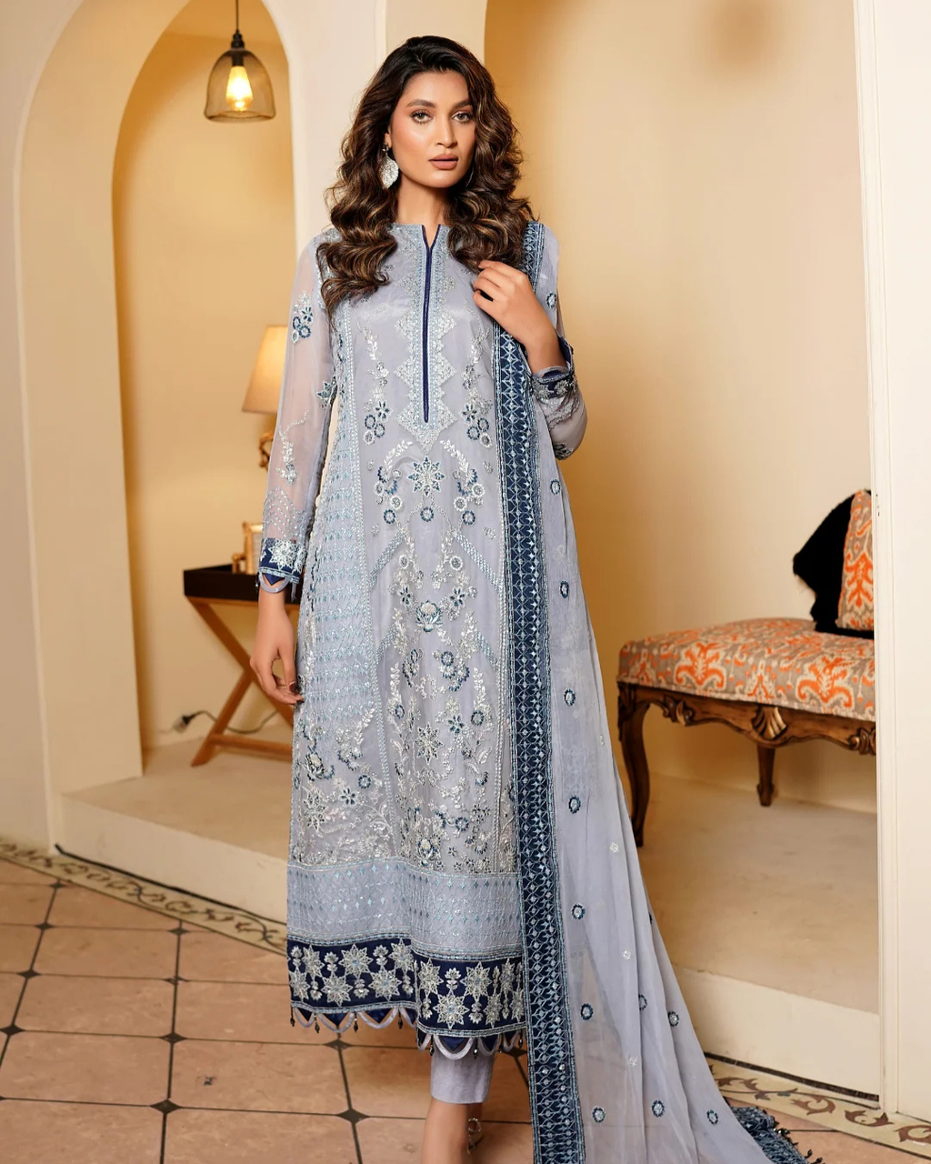 Woman wearing a light blue embroidered dress in an indoor setting