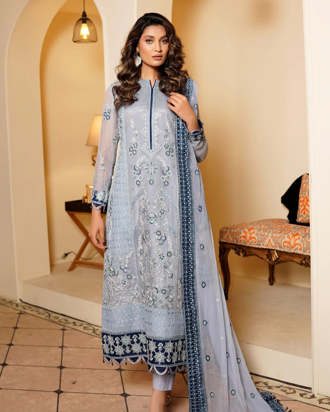 Woman wearing a light blue embroidered dress in an indoor setting
