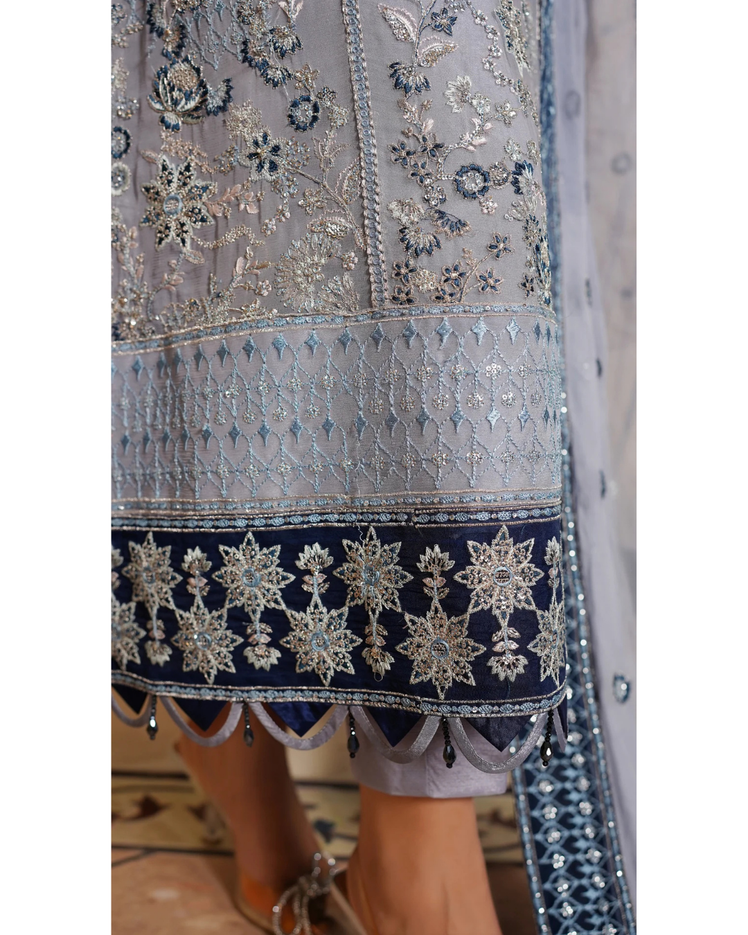 Close-up of a traditional embroidered garment with intricate patterns on a light background