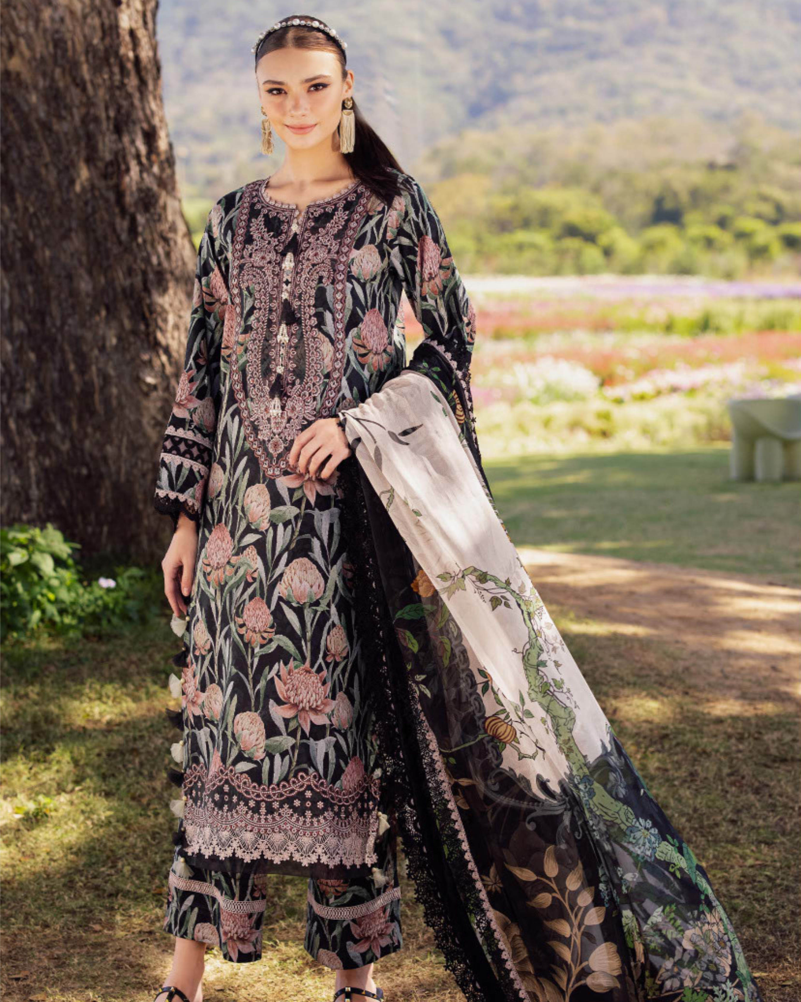 Woman in a floral dress standing outdoors with a scenic background