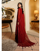 Woman in a red dress standing in an elegant room with decorative elements.