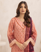 Woman wearing a pink and purple traditional outfit with intricate patterns on a beige background