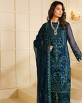 Woman wearing a dark blue embroidered dress with a matching dupatta in an elegant indoor setting.
