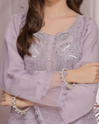 Light purple embroidered blouse with intricate designs on a plain background