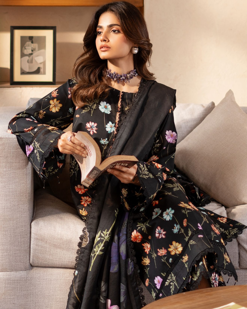 Woman in a floral dress reading a book on a couch