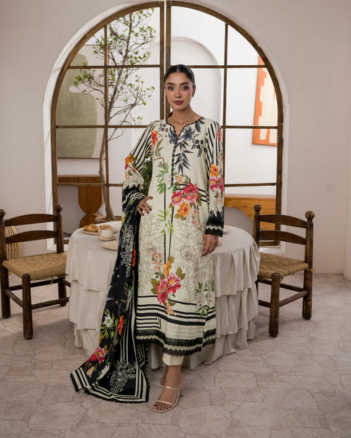 Woman in a floral dress standing in a room with wooden chairs and a table.